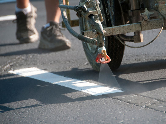 Acme Barricades Employee spraying traffic lines in florida