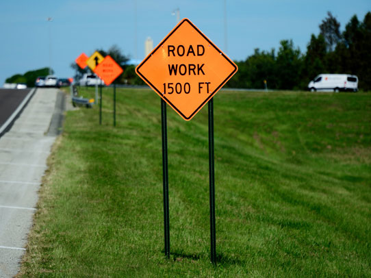 Traffic signs and barricade signs next to a highway in Florida